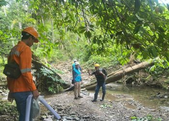 metrodeli/istimewa PENARIKAN JARINGAN : Pegawai dan petugas PLN saat melakukan penarikan jaringan melalui medan yang melewati sungai kecil untuk menuju desa Hiliadolowa, Kecamatan Aramo, Kabupaten Nias Selatan, Sumatera Utara, belum lama ini.