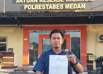 metrodeli/istimewa SURAT LAPORAN: Dody Ariandi menunjukkan surat laporan polisi (LP) di Depan unit Reskrim, Polrestabes Medan, Sabtu, 1 Maret 2025.