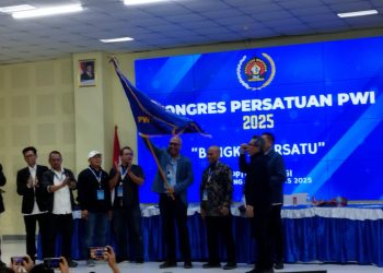metrodeli/alhafiz KIBARKAN BENDERA: Direktur Utama LKBN Antara Akhmad Munir mengibaskan bendera usai terpilih sebagai Ketua Umum PWI periode 2025-2030 dalam Kongres Persatuan PWI yang berlangsung di BPPTIK Komdigi Cikarang Bekasi Jawa Barat, Sabtu 30 Agustus 2025 malam.