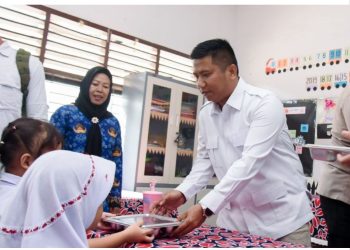 metrodeli/istimewa MAKAN GRATIS : Anggota Fraksi Partai Gerindra Binjai Ronggur Rajadoli Simorangkir menyerahkan makan gratis ke siswa SD.