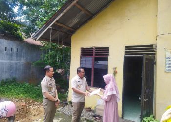 metrodeli/alhafiz SIMBOLIS Kepala Kantor Wilayah ATR/BPN Provinsi Sumatera Utara Sri Pranoto, SSiT, MM didampingi Kepala Kantor Pertanahan Kota Medan Rivaldi, S.SiT.M.M., QRMP secara simbolis menyerahan sertifikat elektronik PTSL kepada warga lingkungan 6 Kelurahan Gedung Johor Kitri Ariana disaksikan Keplingnya 6 Abdi Sofian usai upacara puncak Peringatan Hari Agraria dan Tata Ruang (Hantaru) ke-65, Rabu 24 September 2025.